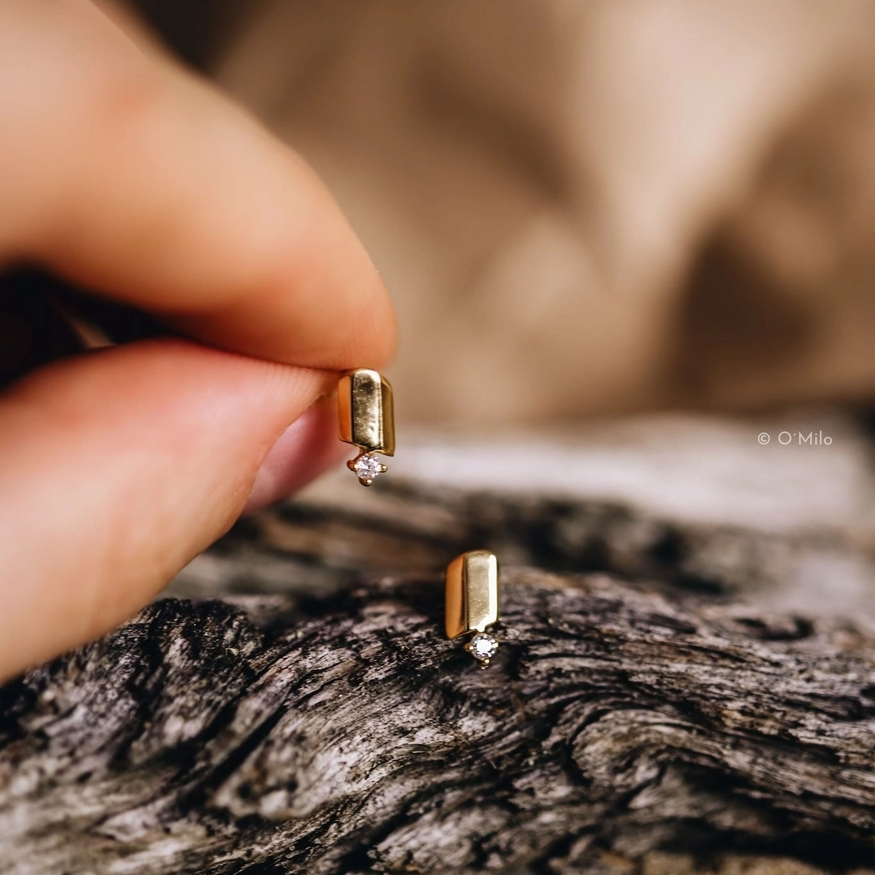 Goldene Ohrstecker mit Diamanten auf Holz