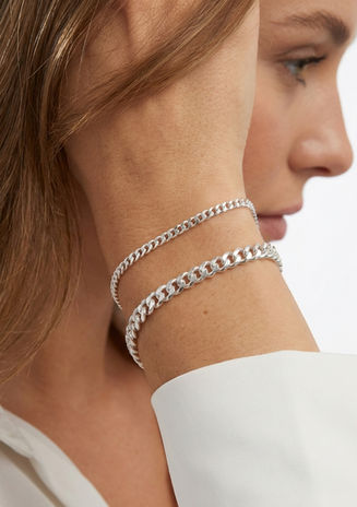 Panzerarmband in Silber am Handgelenk einer Frau