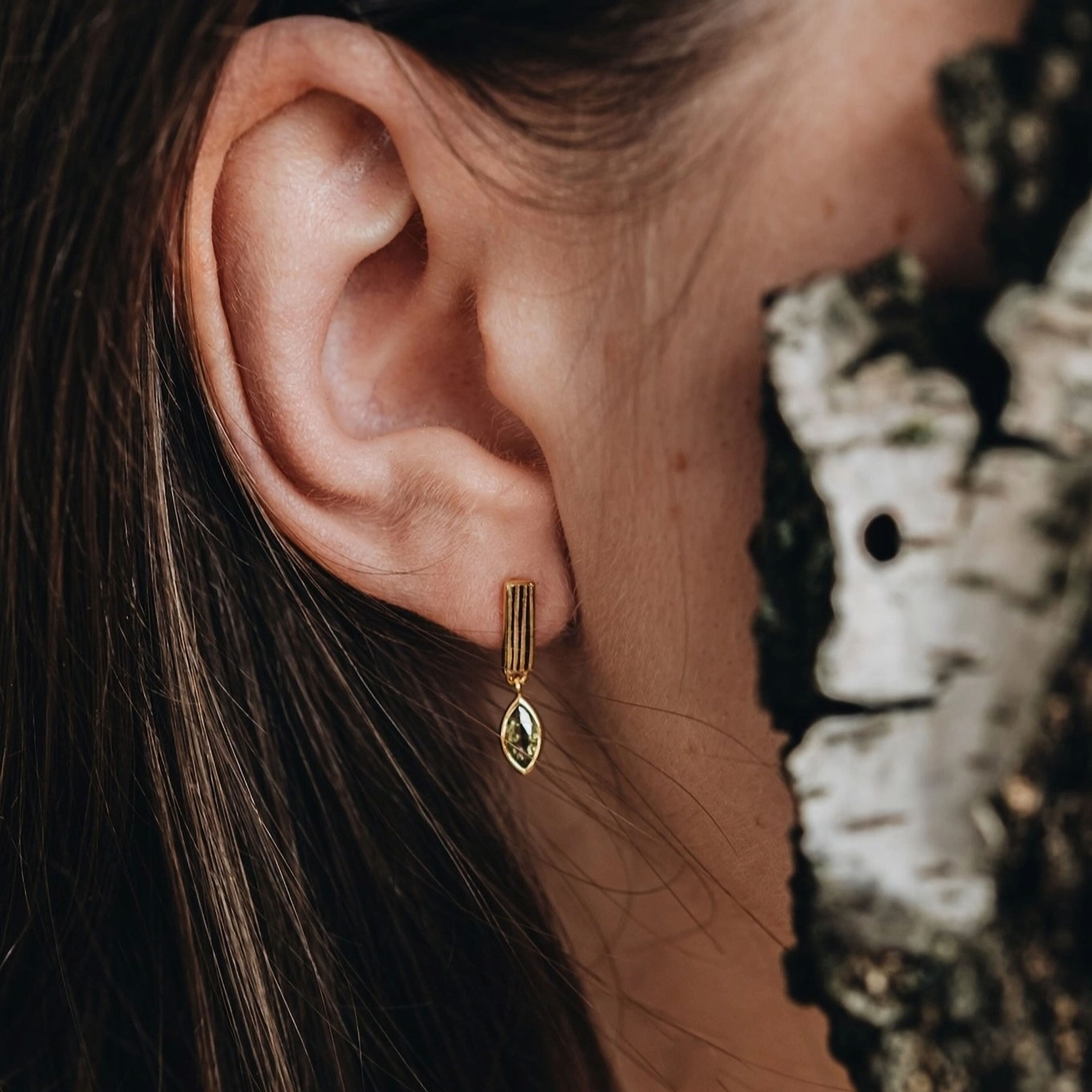 Goldene Ohrringe mit grünem Stein