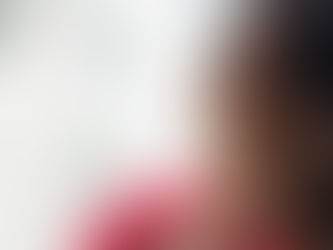 Person in a red shirt holds hand to ear, listening intently. Background is softly blurred with light colors, creating a curious mood.