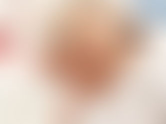 Sleeping baby with electrodes on its head for BERA test. Red and blue wires are visible against a white blanket background. Calm mood.