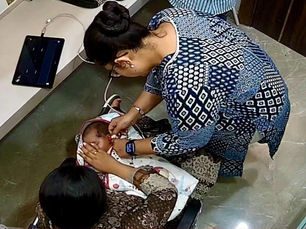 an audiologist performing a newborn hearing screening through OAEs