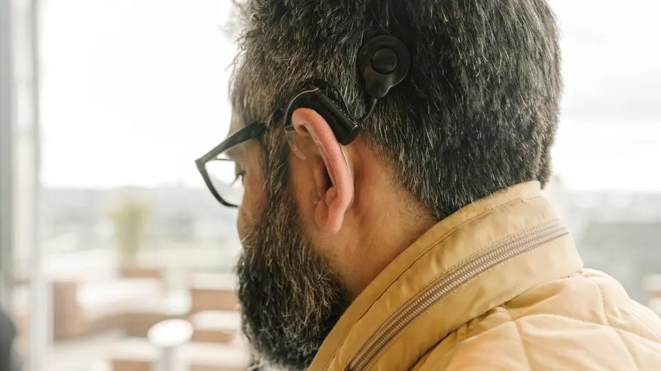 an adult wearing a cochlear processor