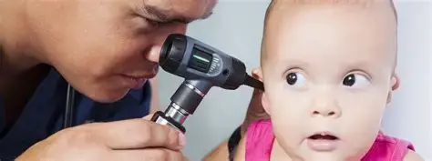 Pediatric Audiologist examines a baby’s ear with an otoscope; the baby looks wide-eyed and surprised in a close-up clinic scene.