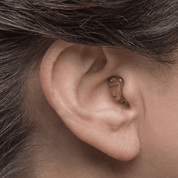 A woman wearing a CIC hearing aid in right ear
