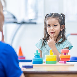 A speech therapist teaching child to speak