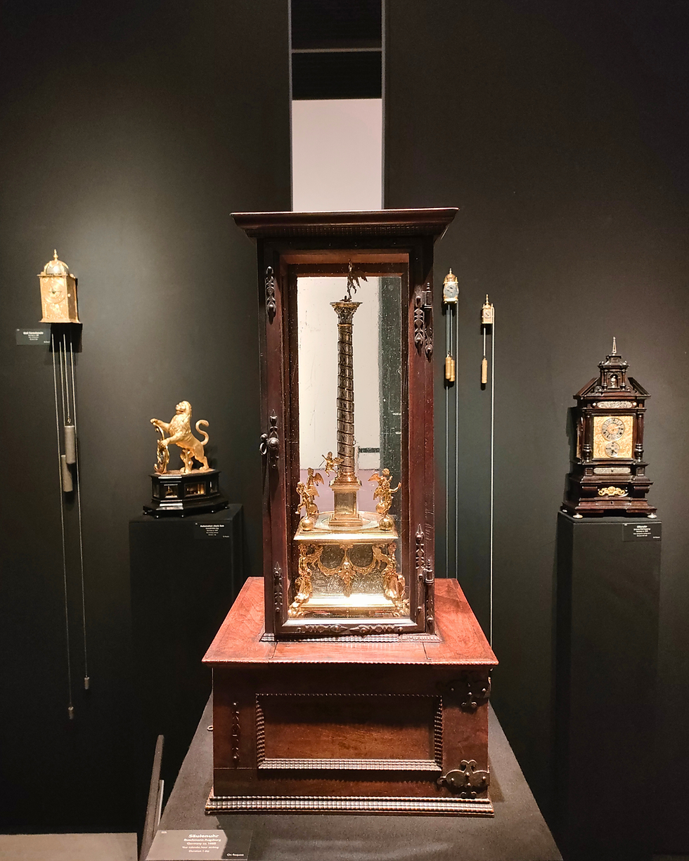 Relógio de mesa em formato de coluna, com vista da base e da vitrine. Fotos de Joana Ferreira, TEFAF Maastricht 2026.