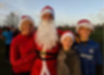 Mother, father dressed as Santa, 2 boys wearing Santa hats