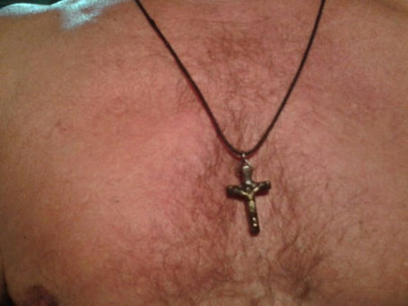 uma cruz no peito de um homem sem camisa