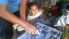 um pintor pintando placas de carros e sua filhinha olhando