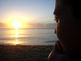 mulher observando o pôr do sol sobre o mar