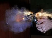 uma mão armada com um revolver no momento do disparo