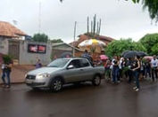 CARRO SEGUIDO POR PESSOAS NA CHUVA