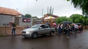 CARRO SEGUIDO POR PESSOAS NA CHUVA