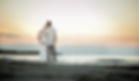 man and pregnant woman on beach in sunset