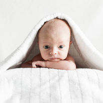 Newborn baby under white towel