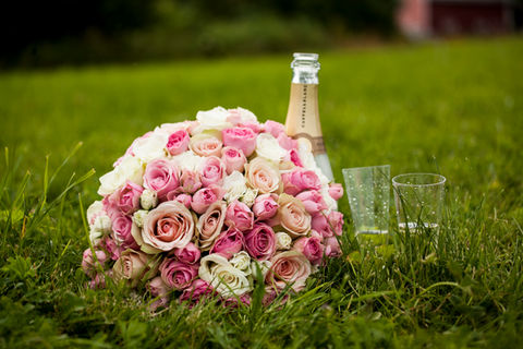 bouquet and champagne and glasses lying in the grass