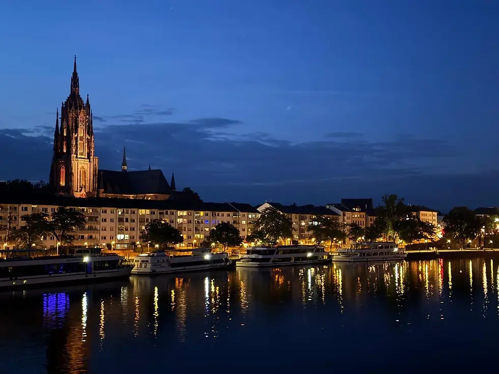 Frankfurt skyline and Cathedral at night by the Main River.