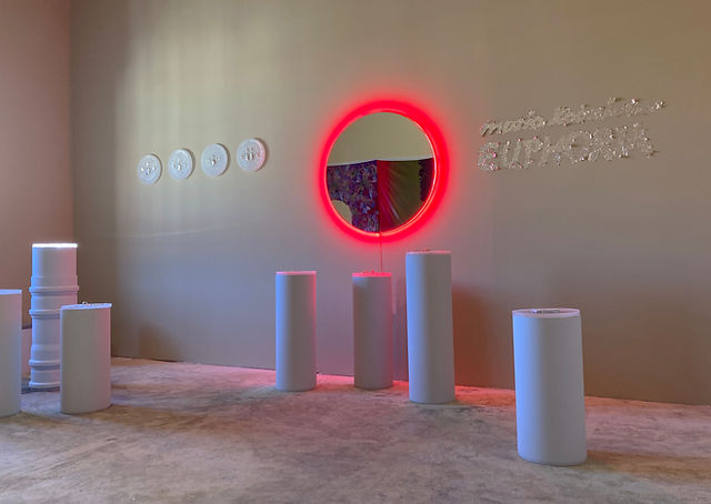 Elegant exhibition space with a large mirror.