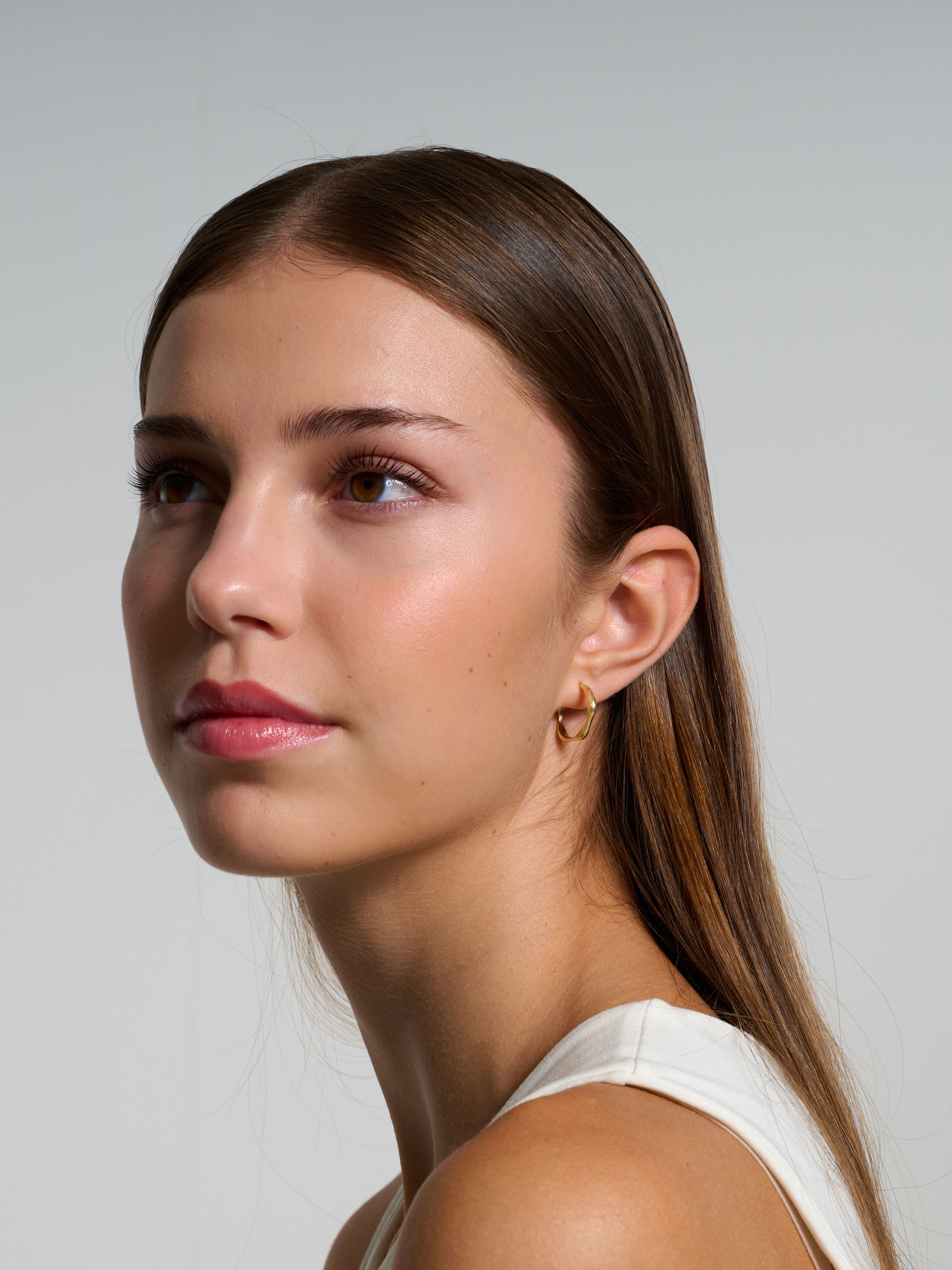 malé zlaté kruhové náušnice s nepravidelným tvarem Es Usus od Márie Kobelové na modelce