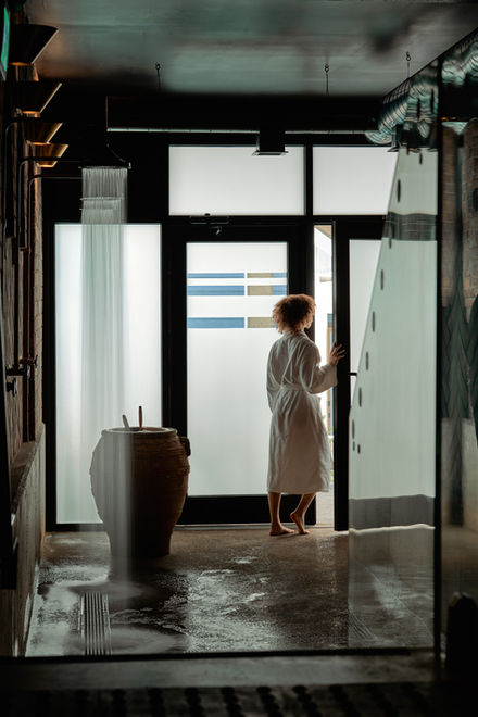 Guest walking through the outdoor courtyard, transitioning between the indoor bathhouse and outdoor wellness spaces.