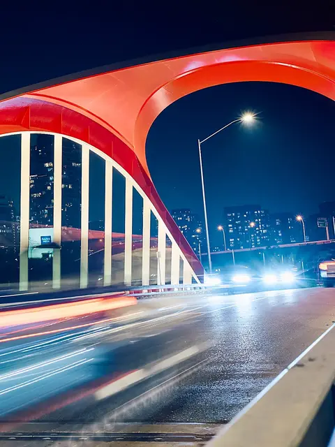 Long exposure of vehicle lights crossing a bridge near Biidaasige Park at night