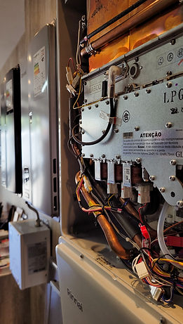 Expositor de peças internas de aquecedor de água Rinnai Heavy Duty E43 e aquecedores ao fundo com sistema de recirculação Rinnai Smart Start