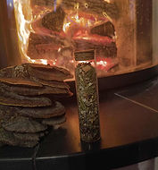 Incense mixture in the foreground, behind it a burning tiled stove.