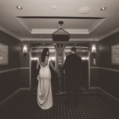Wedding couple holding hands at elevator