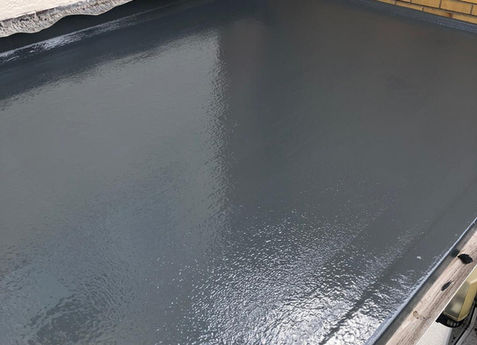 Seamless grey GRP fibreglass flat roof installation showing high-quality topcoat finish and lead flashing in Dorset.