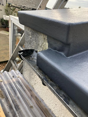 Close-up of professional grey waterproof coating on a complex roof junction for an emergency repair in Dorset.