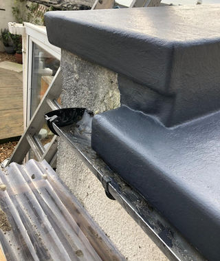 Close-up of professional grey waterproof coating on a complex roof junction for an emergency repair in Dorset.