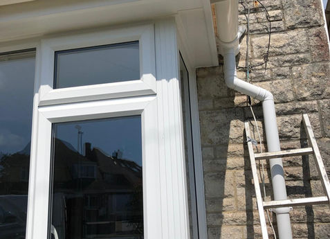 New white uPVC fascias, soffits, and guttering installed on a stone property in Dorset for improved drainage.