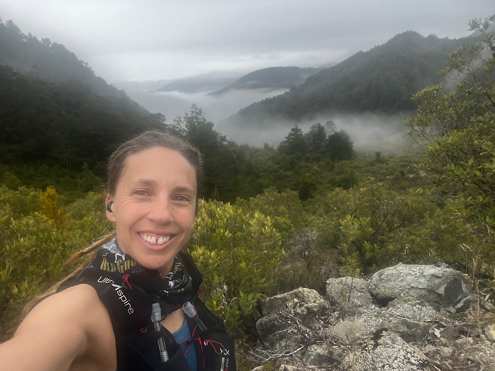 A trail runner taking a selfie with vies of mountains and low hanging cloud on the old ghost road.