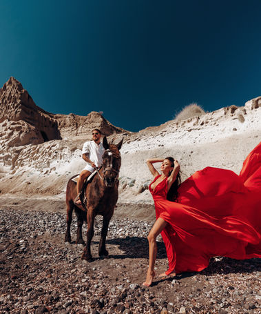 Santorini beach photoshoot with horse and flowing dress