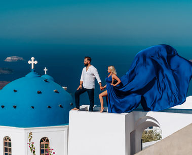 Elegant Santorini honeymoon photoshoot with cliffside scenery near blue domes