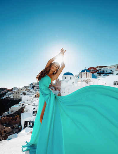 Fashion portrait with flying dress in Oia Santorini