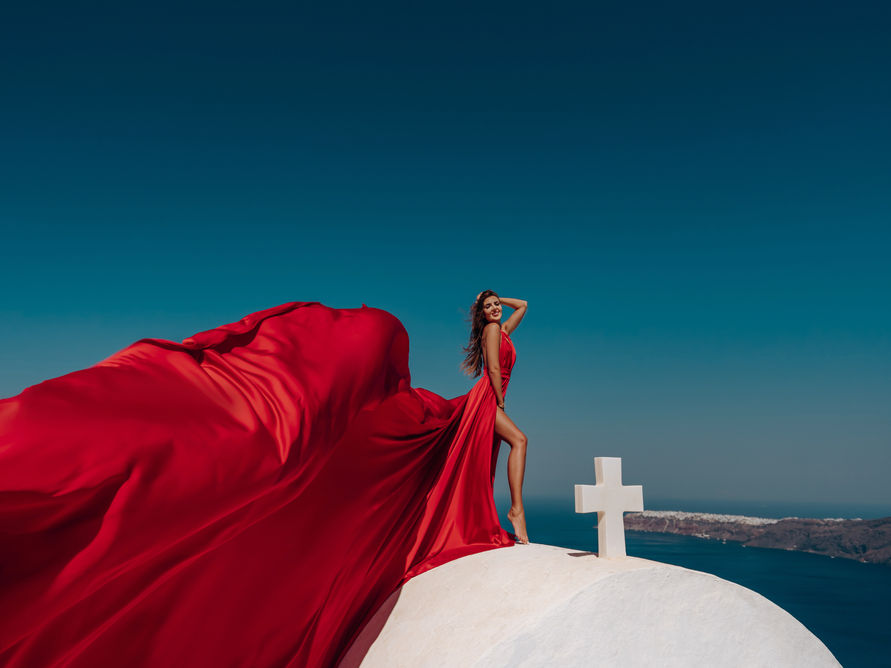santorini flying dress photoshoot woman blue dress imerovigli white church