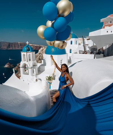 Couple flying dress photoshoot in Santorini with blue dome background