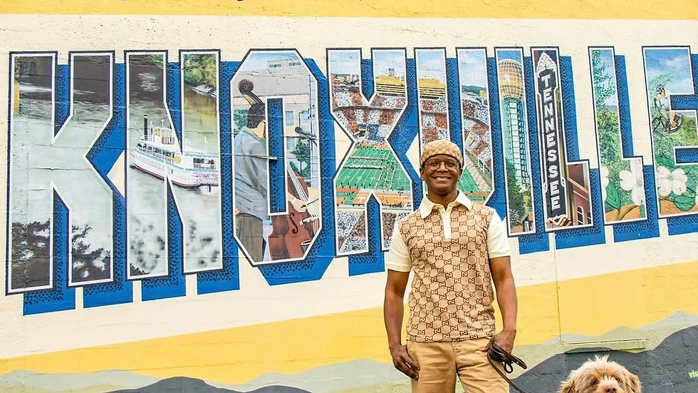 Man and dog standing in front of the Greetings from Knoxville mural