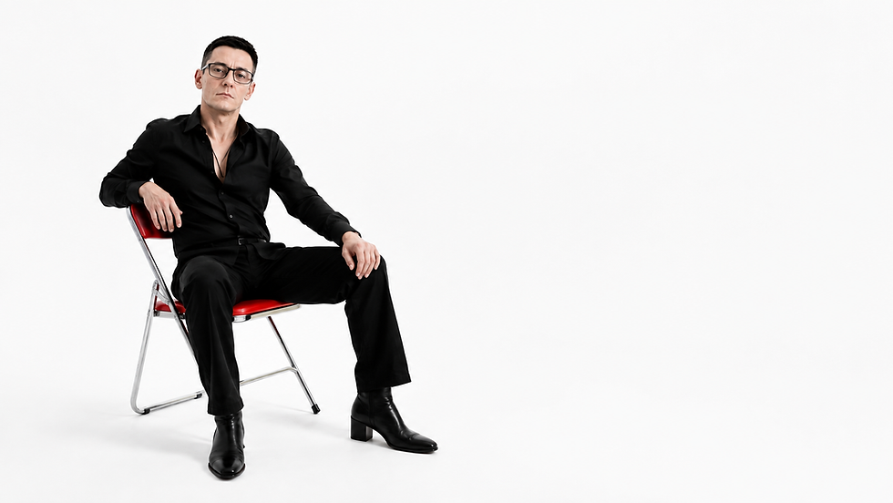 Sè Bān, auteur-compositeur-interprète de variété française, assis sur une chaise.