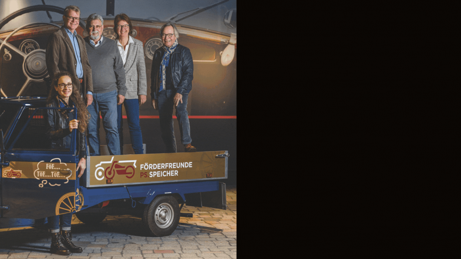 Fünf Personen stehen hinter einer kleinen blauen Ape mit goldener Ladefläche, auf der das Logo der FörderFreunde PS.SPEICHER 