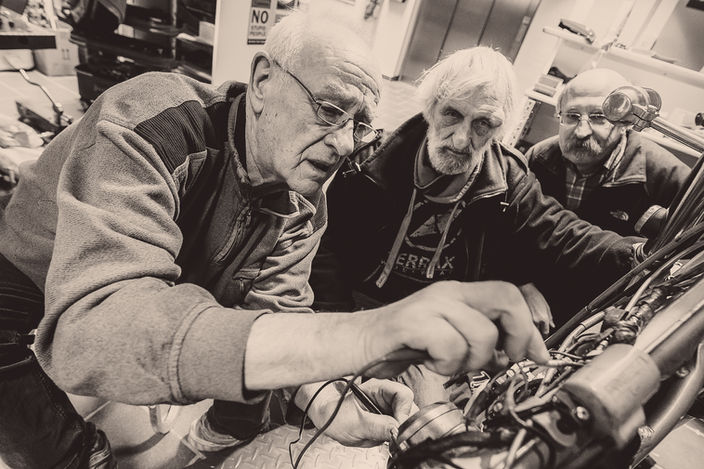 Drei Männer reparieren eine Maschine im PS.SPEICHER.