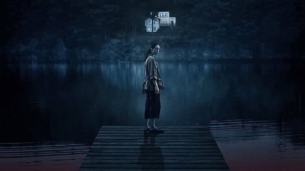Rebecca Hall as Beth, standing on a dock by the lake with the eerie reflection of the house in the water, from The Night House.