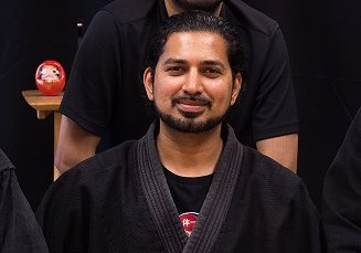 Omar Gilani Sensei, founder of Shadow Combatives, wearing a black gi in a martial arts profile photo.