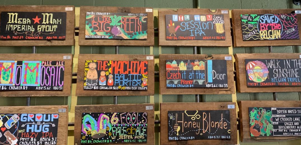 A variety of hand painted chalkboard signs representing a dozen different beers.