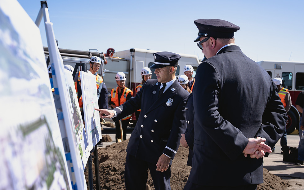 A San Francisco Fire Department official points at a rendering of the new fire training facility while explaining some details to other colleagues.