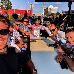 Groepsmoment van een tussenstop op een begeleide fietsreis. De deelnemers drinken samen iets om te recupereren van de gedane fietsrit