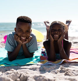 213986406-portrait-of-african-american-happy-siblings-with-hands-on-chins-lying-on-towels-