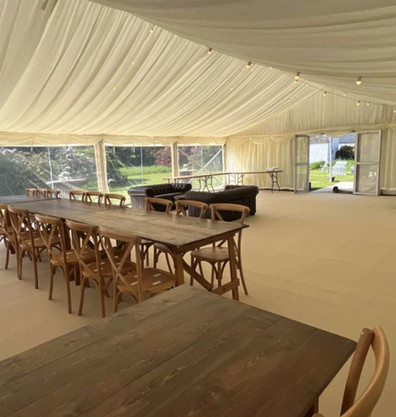 Garden wedding with rustic tables, cross back chairs, cream carpet and full internal lining